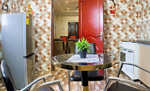 een keuken met een tafel, stoelen en een koelkast bij Two Bedrooms Standby Generator DSTV Netflix W-iFi in Takoradi