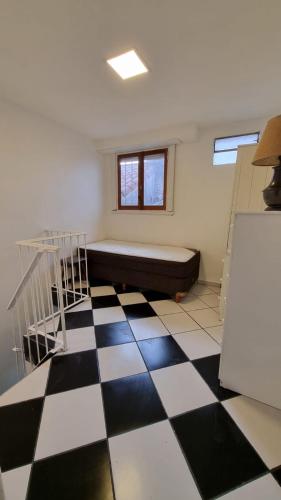 Cette chambre dispose d'un lit et d'un sol en damier. dans l'établissement Check and Home - Casa San Luis - 6 Huéspedes en Barrio Chauvin, à Mar del Plata