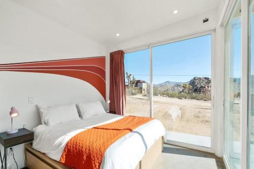 une chambre avec un lit et une grande fenêtre dans l'établissement Stars on the Rocks - Pool, HotTub, FirePit, Boulders!, à Joshua Tree