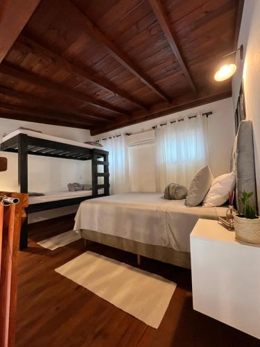 a bedroom with a bed and a wooden ceiling at Chale aconchegante da ilha in Florianópolis