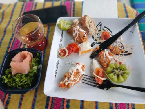 a plate of food on a table with a glass of wine at Voyager autrement sous les iles sous le vent in HUH