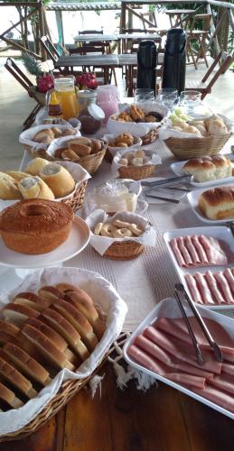 een tafel met veel verschillende soorten voedsel bij Pousada Estância Mineira in Guapé