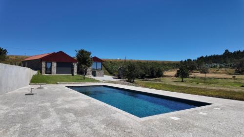 a swimming pool on a patio with a house at Casa Memórias da Lucinda in São Gens