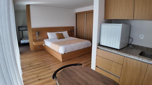 a small room with a bed and a kitchen at Casa Memórias da Lucinda in São Gens