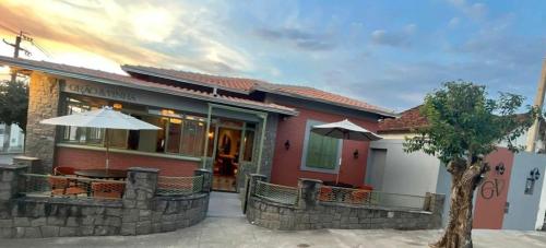 a building with a table and an umbrella at Pousada Grão & Vinha in Espirito Santo Do Pinhal