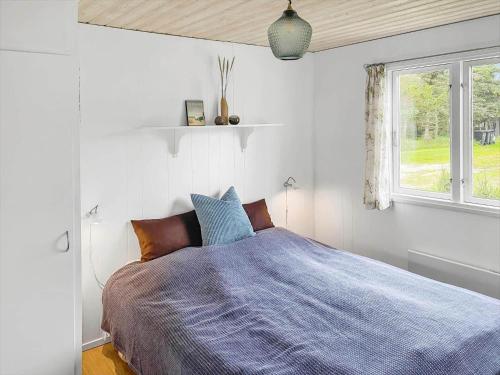 a bedroom with a bed with a blue comforter and a window at 162-Thisted-Molgaardsvej-62 in Thisted