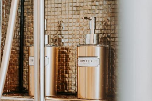 two gold water tanks are sitting in front of a wall at Topaz Scape Garajau Madeira by GRM in Caniço