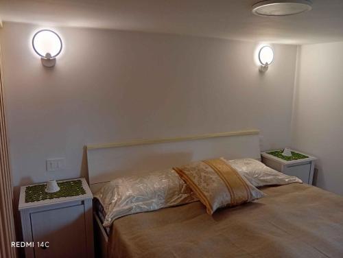 a bedroom with a bed and two lights on the wall at villa del mare in Nettuno