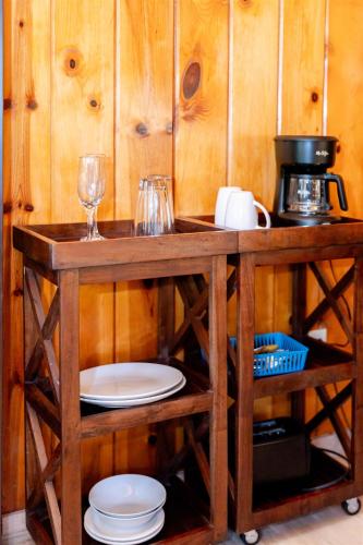 a wooden table with plates and glasses and a coffee maker at Fern River Resort in Felton