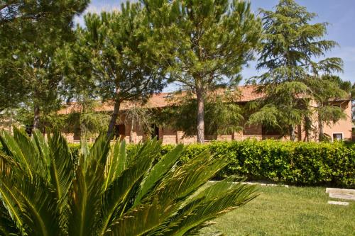 a park with trees and a building in the background at Fattoria San Lorenzo in Grosseto