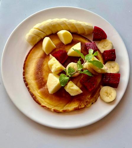 ein Teller mit einem Pfannkuchen mit Obst darauf in der Unterkunft THE PLACE Hostel Phnom Penh in Phnom Penh