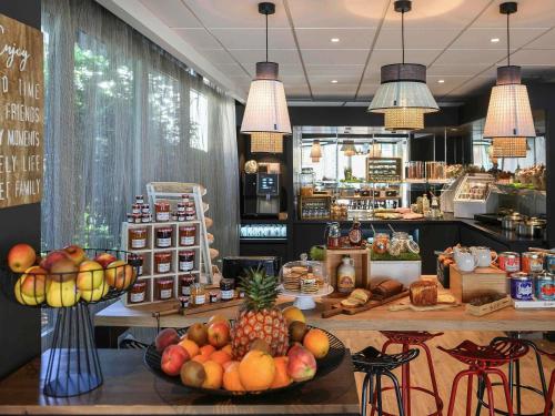 una tienda de comestibles con una exposición de frutas y hortalizas en Hotel Novotel Evry Courcouronnes, en Courcouronnes