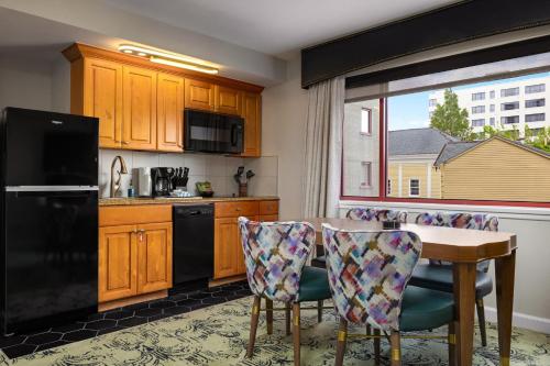 a kitchen with a table and a black refrigerator at Club Wyndham Avenue Plaza in New Orleans