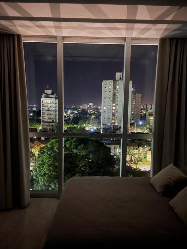 a bedroom with a view of a city at night at Charlotte Belgrano Posadas in Posadas