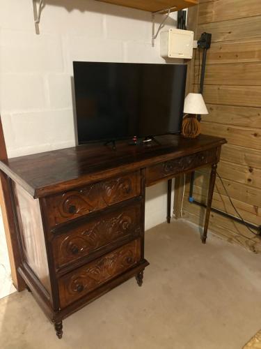 a wooden dresser with a television on top of it at Suítes Cabanas Coral in Serra