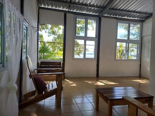 a room with a table and a bench and windows at Casa Lunama in Piedra Blanca