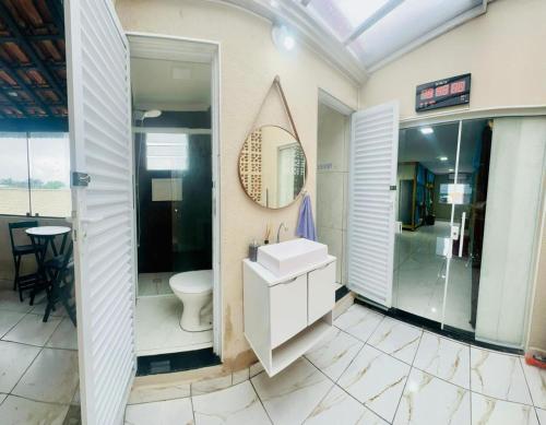 a bathroom with a sink and a shower and a toilet at Casa Praia e hostel in Praia Grande