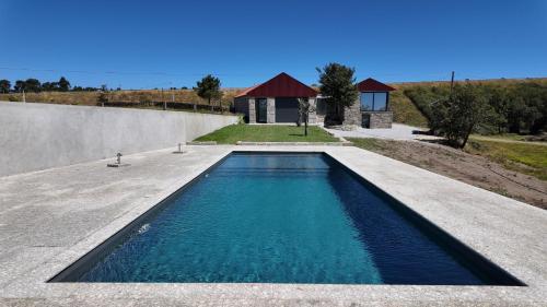 a swimming pool in front of a house at Casa Memórias da Lucinda in São Gens