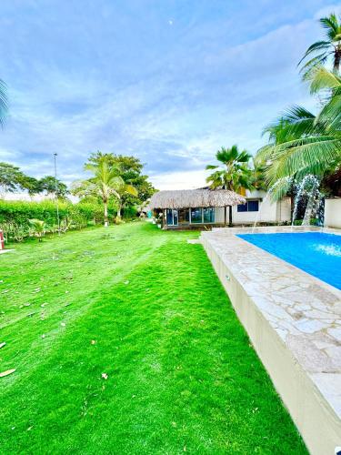 a yard with a swimming pool next to a house at Playa Virginia Beach House Privada in San Silvestre