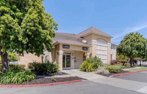 a building with a tree in front of it at Extended Stay America Suites - San Jose - Sunnyvale in Sunnyvale