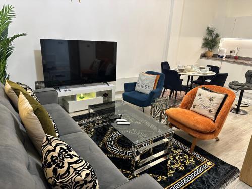 a living room with a grey couch and a table at Mega7 Spacious 2Bedroom Apartment, 2 Bathrooms, Balcony and Free Parking in Manchester