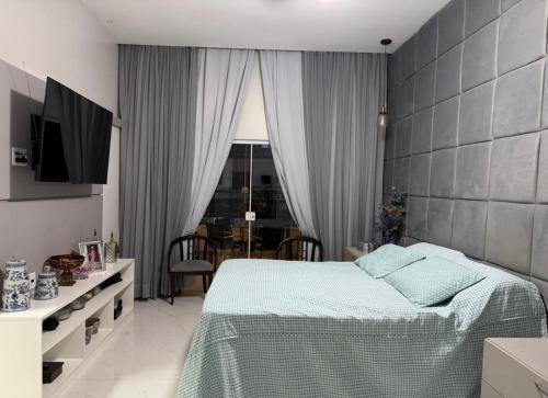 a bedroom with a bed and a table and a window at Lar dos Fernandes in Belém