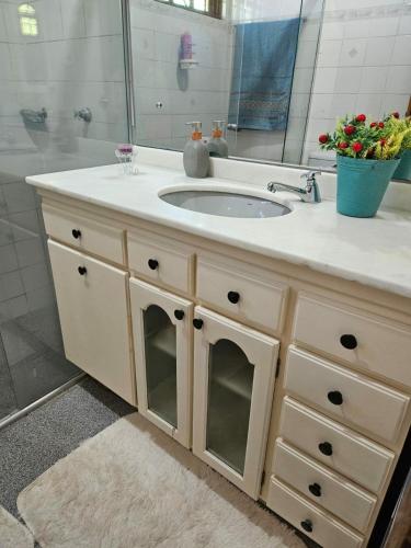 a bathroom vanity with a sink and a mirror at Recanto Don Ciro in Uruguaiana