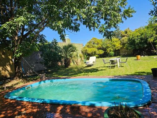 einen Pool im Garten mit Tisch und Stühlen in der Unterkunft Recanto Don Ciro in Uruguaiana