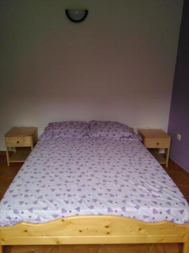 a bedroom with a wooden bed with purple sheets at Damontanha in Ribeira Grande