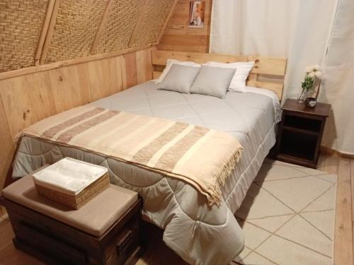 a bedroom with a large bed with a wooden wall at Sigchos Lodge in Sigchos