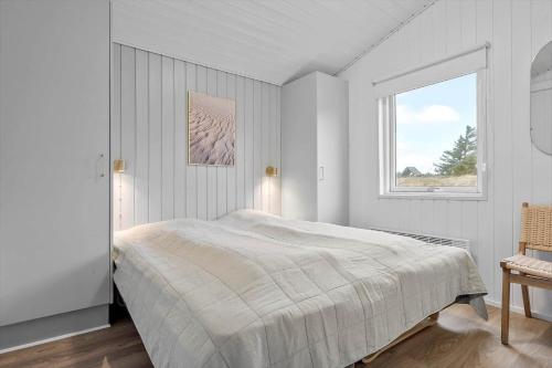 a white bedroom with a bed and a window at 340-Hvide-Sande-Fyrmarken-21 in Hvide Sande