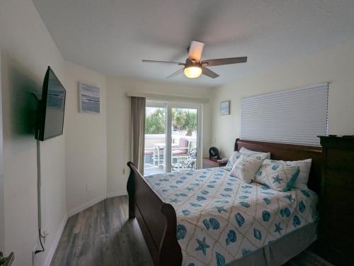 una camera da letto con un letto e un ventilatore a soffitto di Oceanfront 2br2b, Ocean Views, Heated Pool, Spa a Cape Canaveral