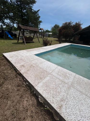 a swimming pool with a picnic table and a playground at Quinta El Oasis Junin in Junín