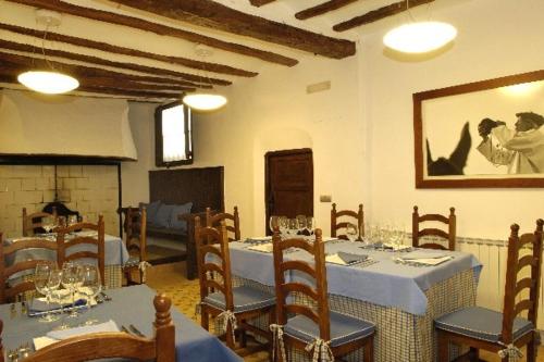 comedor con mesas y sillas y chimenea en La Casona del Solanar en Munébrega