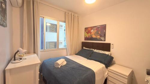 ein kleines Schlafzimmer mit einem Bett und einem Fenster in der Unterkunft Apartamento perto de tudo, vista mar, AC quente, Wifi 300mb in Balneário Camboriú