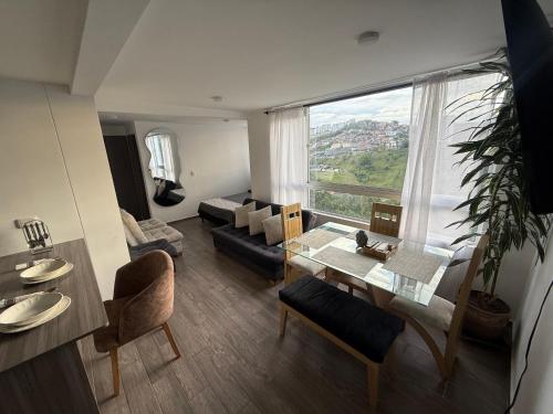 a living room with a table and a large window at Simplemente en Casa! in Manizales