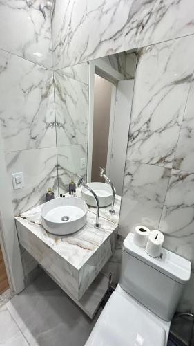 Un baño con lavabo, inodoro y espejo. en Prime Hostel BH, en Belo Horizonte