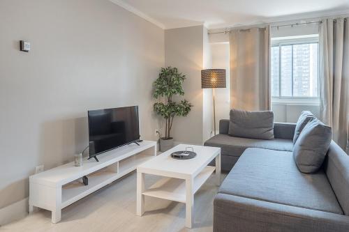 a living room with a couch and a tv at Cozy 1BR - Heart of Montreal in Montréal