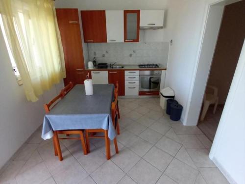 a small kitchen with a table and chairs in it at Classic One Bedroom Apartment with Terrace and Sea view in Sveta Nedelja