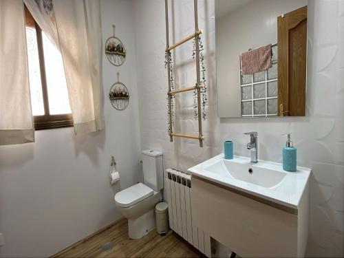 een witte badkamer met een toilet en een wastafel bij La Chicuela Rural House in Los Villares in Los Villares