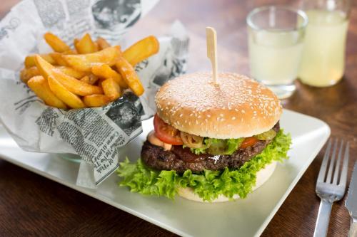 a hamburger and french fries on a white plate at Strandhotel Ostseeblick in Heringsdorf