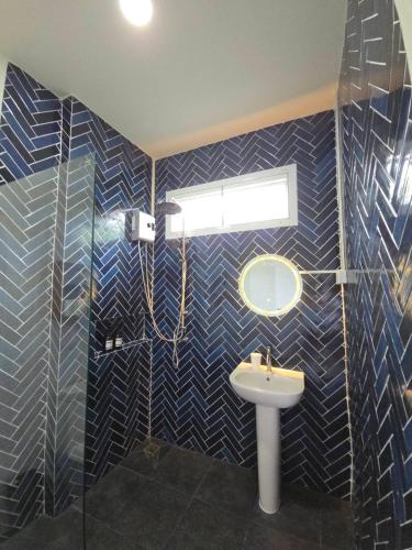 a bathroom with blue tiled walls and a sink at The Simple Place - King and Twin in Klong Muang Beach