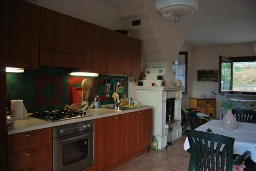 a kitchen with wooden cabinets and a stove top oven at Casa Emma in SantʼEufemia a Maiella