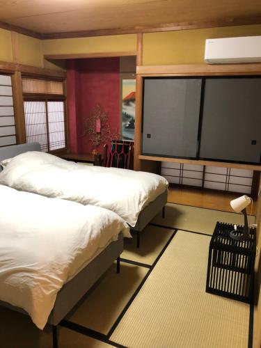 a bedroom with two beds and a flat screen tv at T'S House Numazu in Numazu