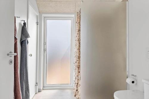 a bathroom with a door with a window and a sink at 382-Harboore-Charlottevej-6 in Harboør