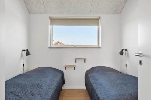 two beds in a bedroom with a window at 382-Harboore-Charlottevej-6 in Harboør