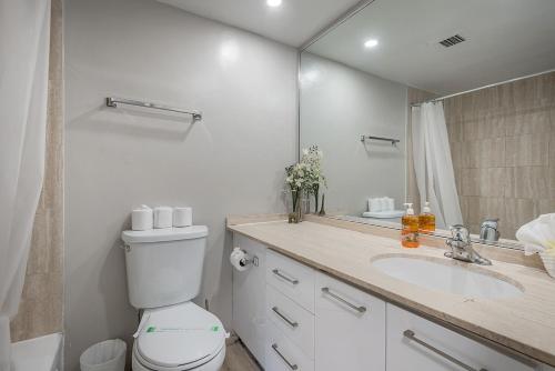 a bathroom with a toilet and a sink and a mirror at Cozy 1BR - Heart of Montreal in Montréal