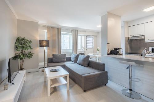 a living room with a couch and a kitchen at Cozy 1BR - Heart of Montreal in Montréal