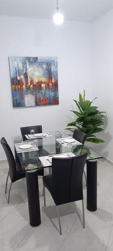 a dining room with a table and chairs and a painting at Appartement azrou in Azrou