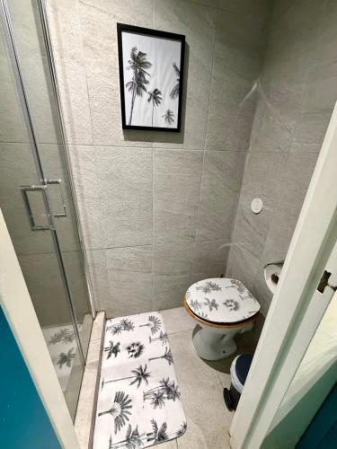 a bathroom with a shower and a toilet and a picture at Studio Ti Saphir in Le Diamant